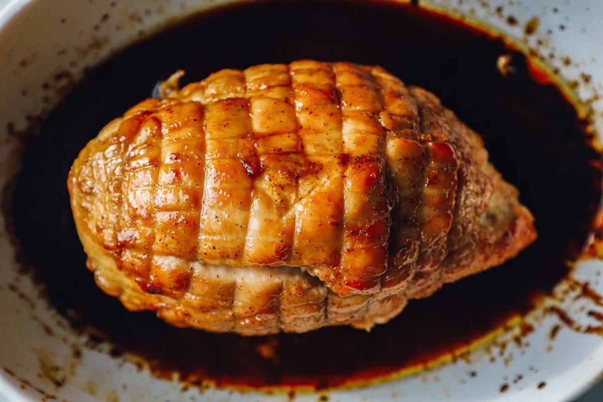 overhead view of honey baked turkey breast in a white baking dish.