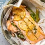 Lemon butter salmon cooked in parchment paper with asparagus.