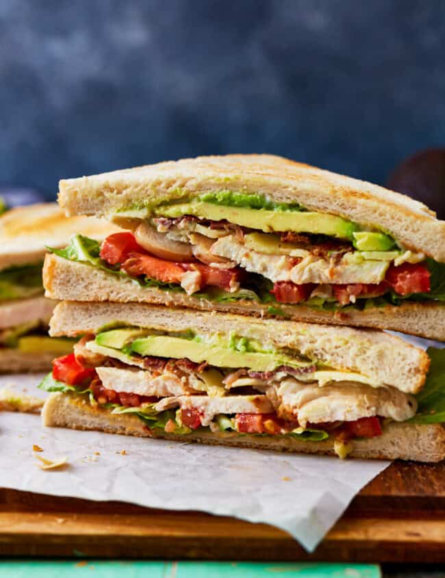 side view of a halved and stacked chicken club sandwich.