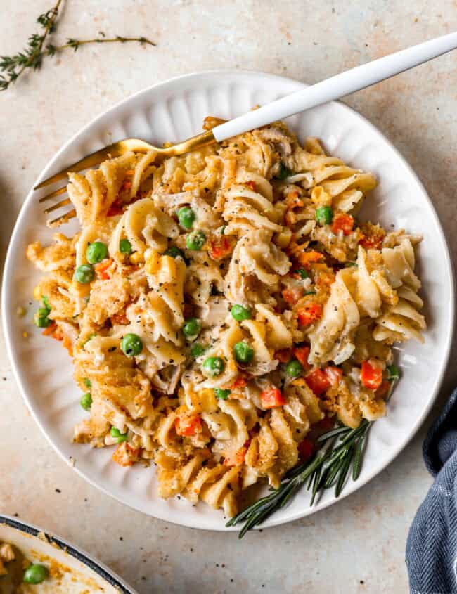 overhead view of a serving of chicken noodle casserole on a white plate with a fork.