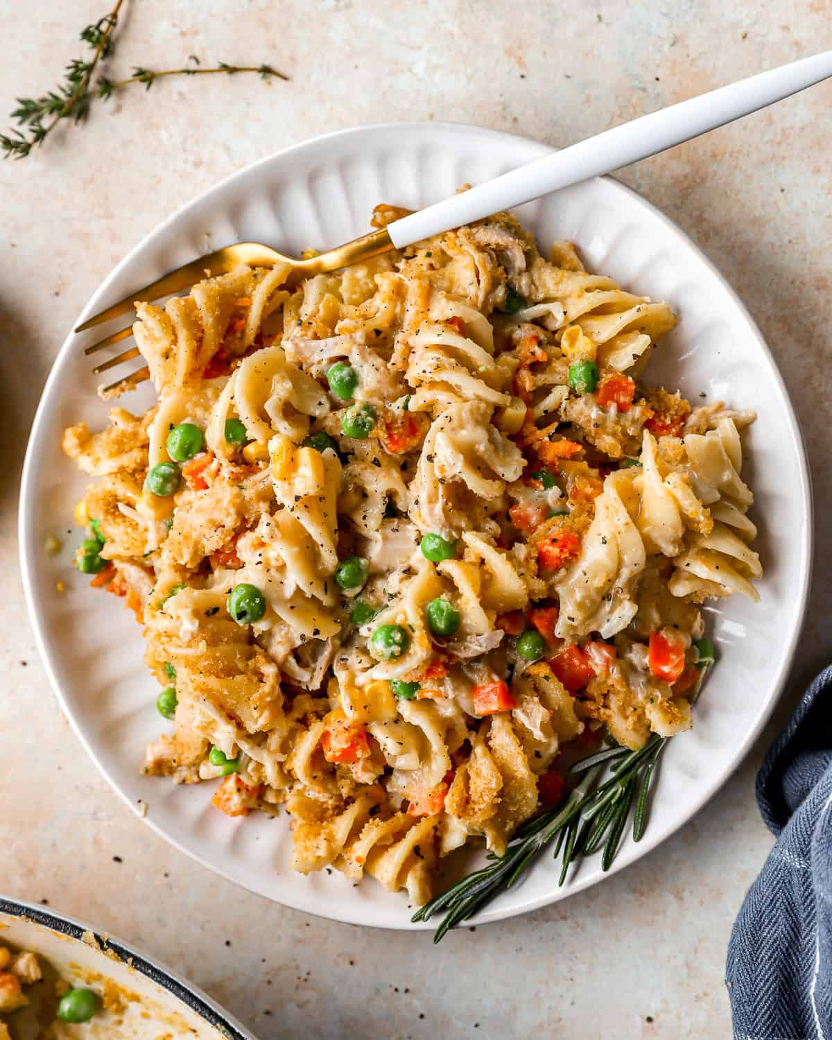 overhead view of a serving of chicken noodle casserole on a white plate with a fork.