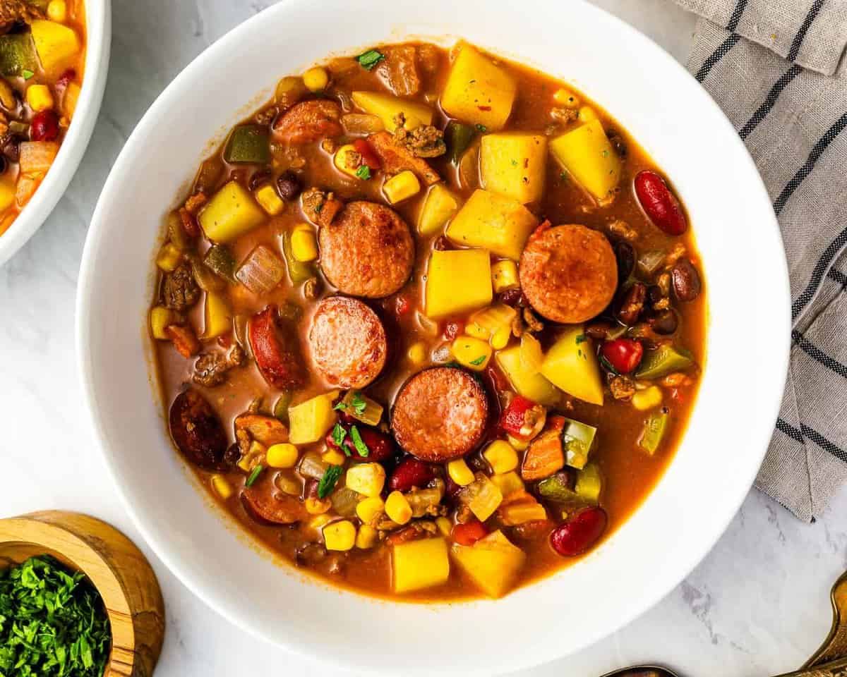 overhead view of a serving of cowboy stew in a white bowl.