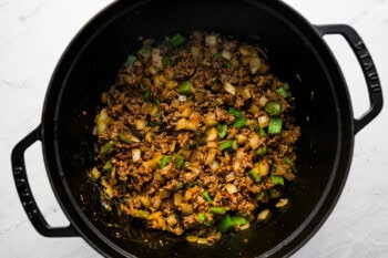 seasoned ground beef and veggies cooking in a dutch oven.