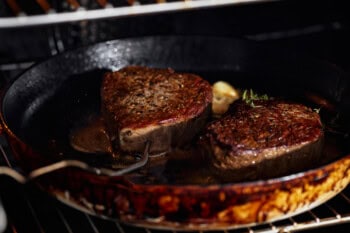 cooking filet mignon in a pan.