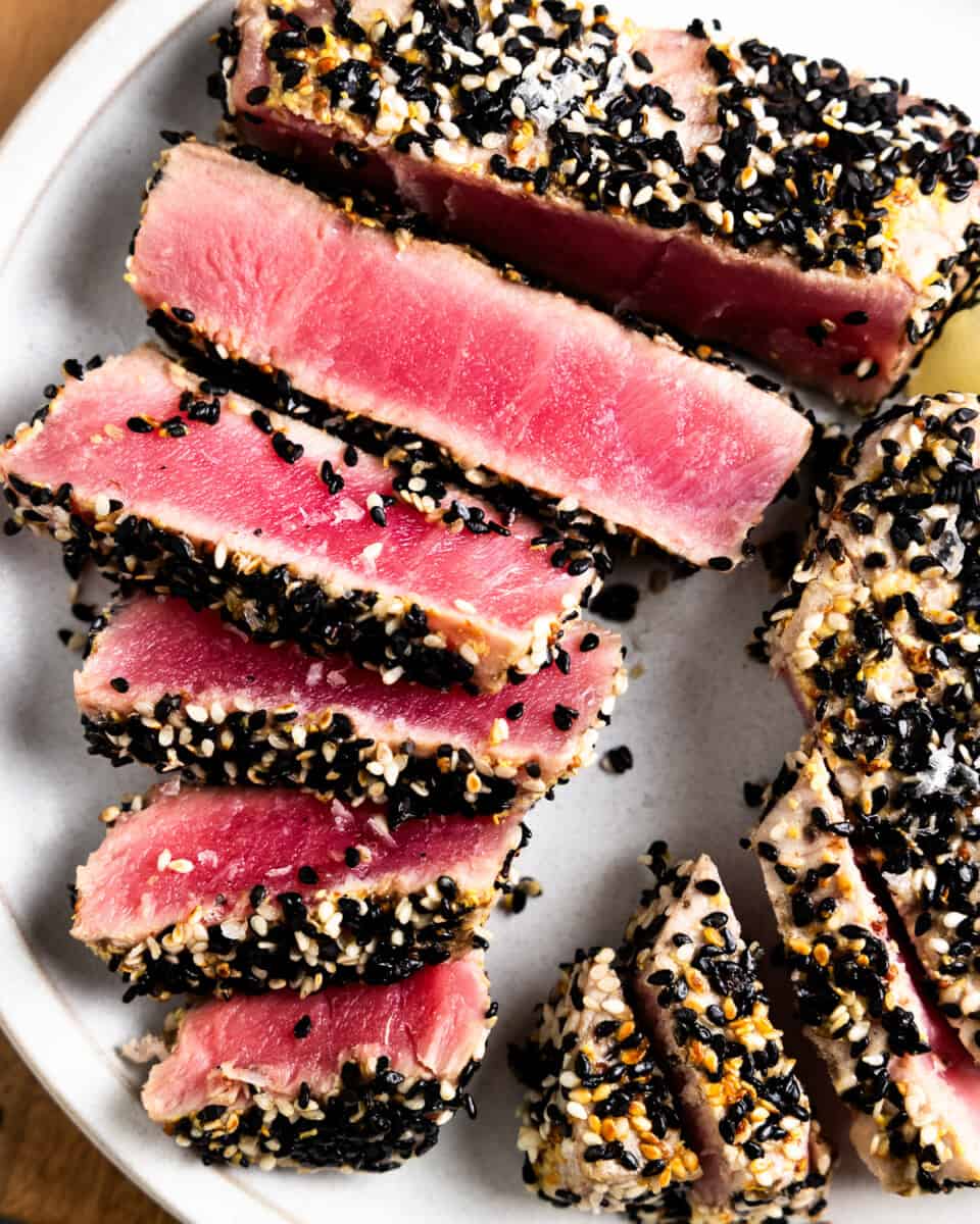 slices of sesame crusted ahi tuna on a white plate.