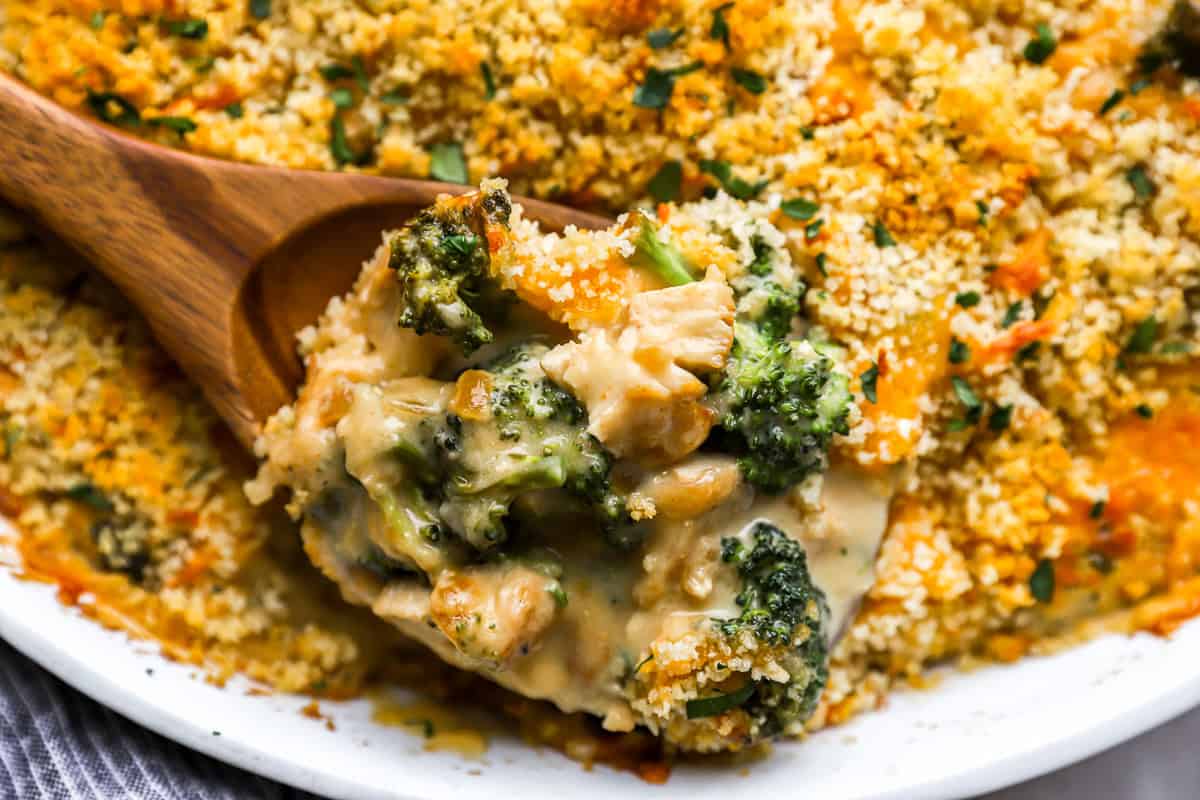 close up on a wooden spoon with a scoop of chicken and broccoli divan.