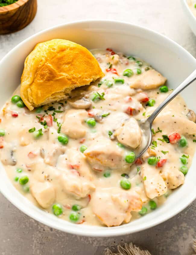 A bowl of Chicken a la King with peas and mushrooms.