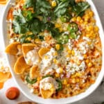 overhead view of mexican street corn dip in an oval baking dish.