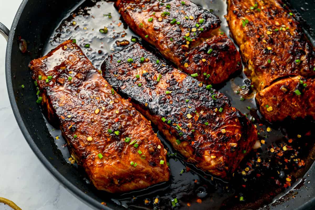 close up view of firecracker salmon fillets in a frying pan.