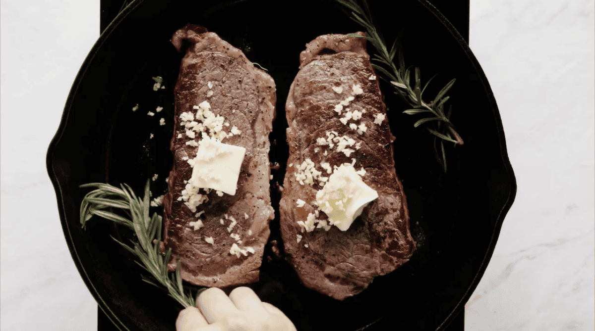 pan-seared ribeyes topped with butter and garlic.