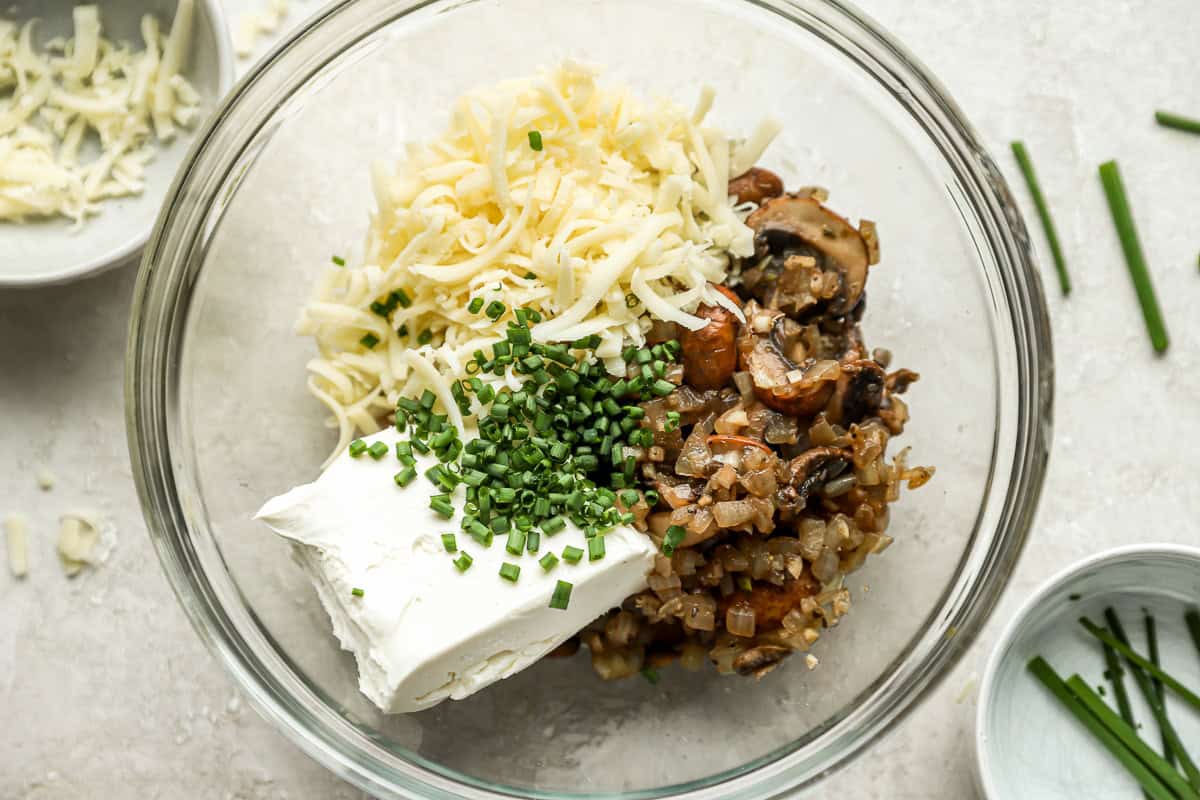 mushroom filling mixed with cheese, cream cheese, and chives in a glass bowl.