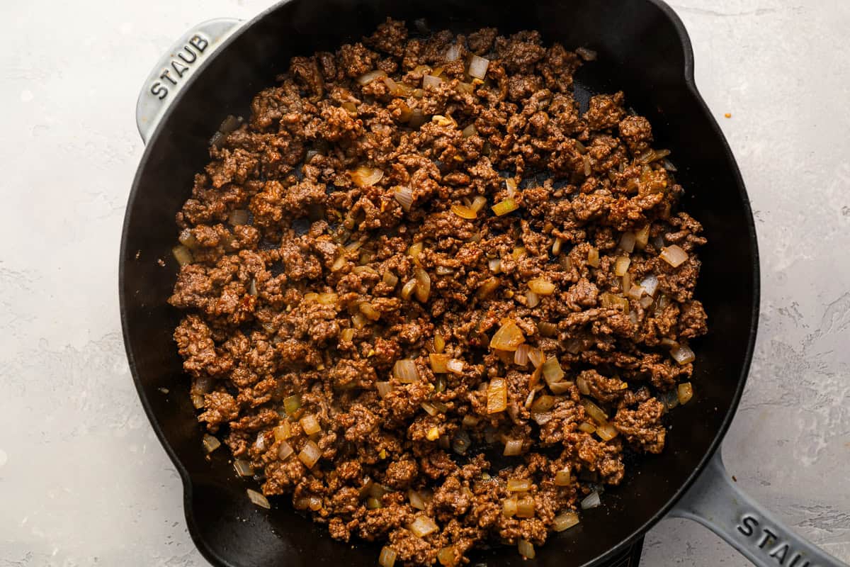 cooked seasoned ground beef and onions in a pan.