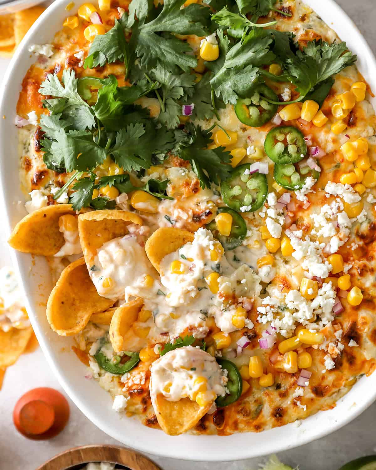 overhead view of mexican street corn dip in an oval baking dish.