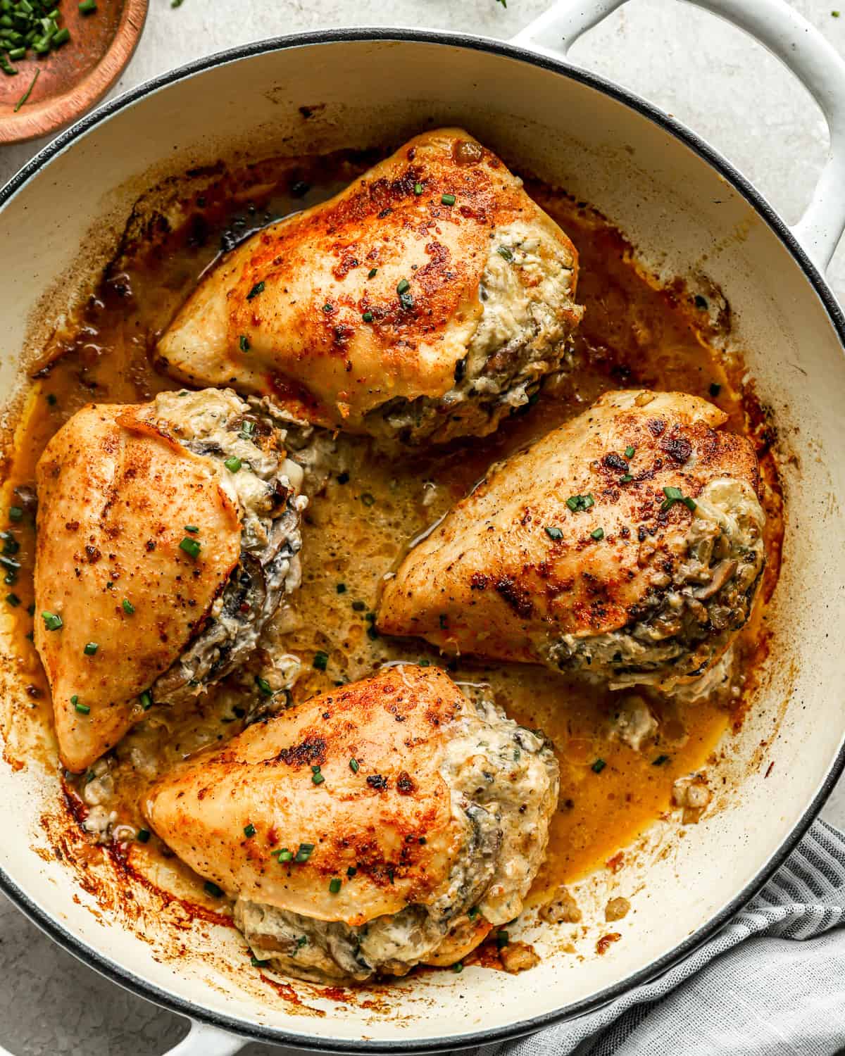 mushroom stuffed chicken breasts in a pan.