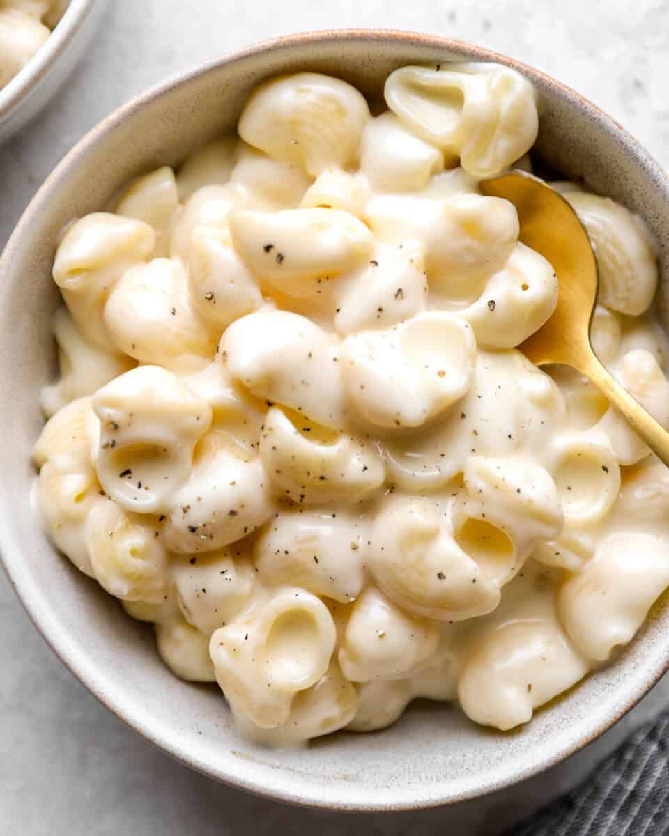 close up view of panera mac and cheese in a bowl with a spoon.