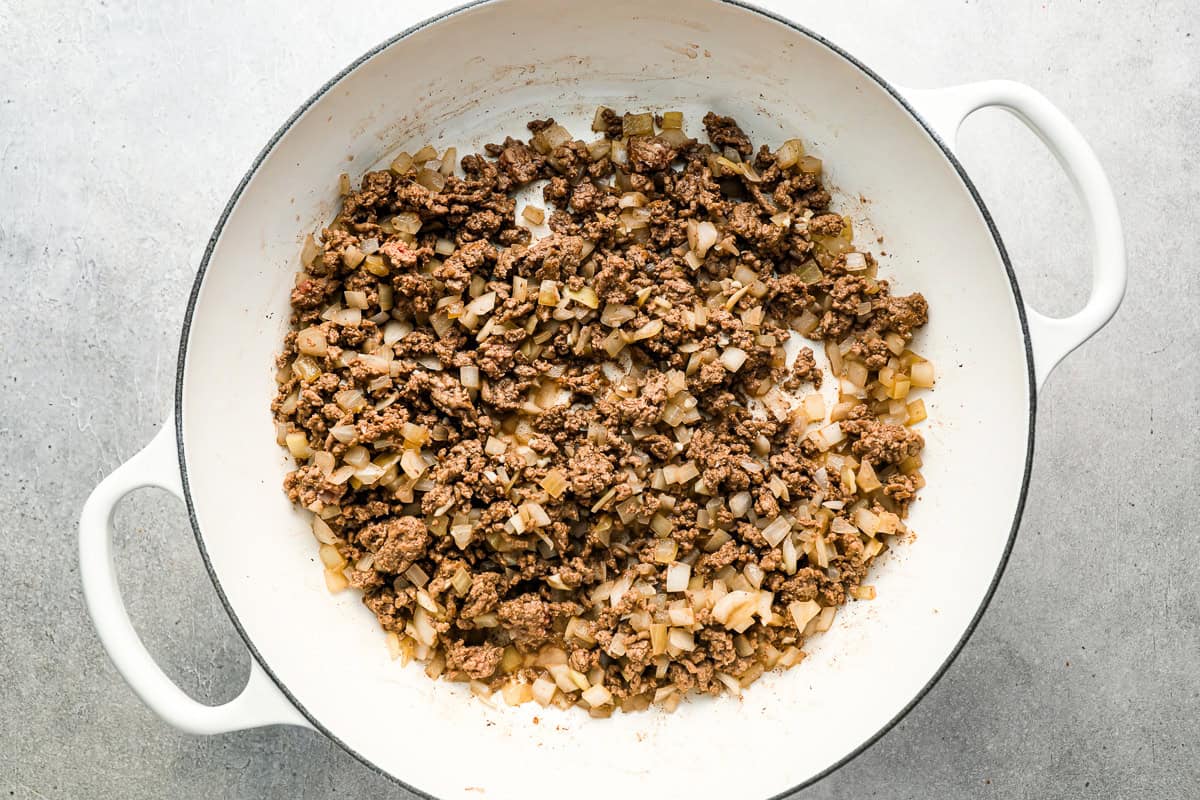 ground beef and onions cooking in a pot.