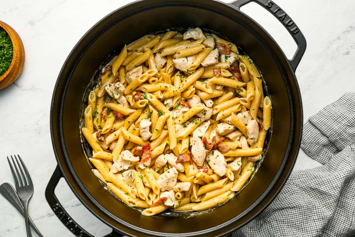 Pasta with chicken, bacon, and ranch seasoning in a dutch oven.