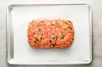 unbaked meatloaf on a baking sheet.