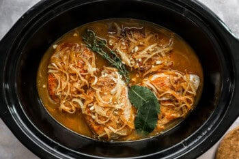 pork chops, gravy, onions, and herbs in a crockpot.