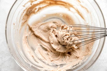 whipping honey, cinnamon, and butter in a glass bowl with a whisk.