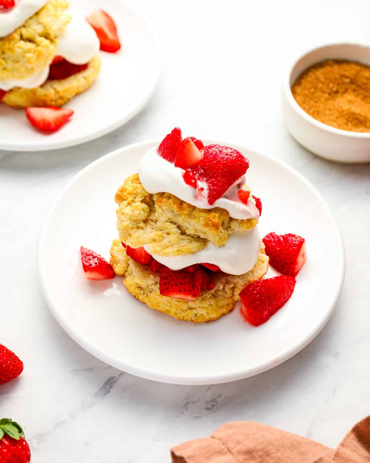 a serving of strawberry shortcake on a white plate.