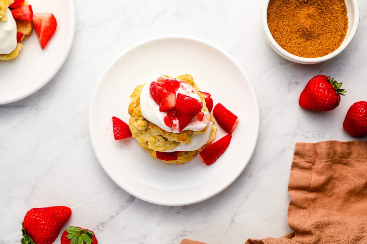 overhead view of a serving of strawberry shortcake on a white plate.