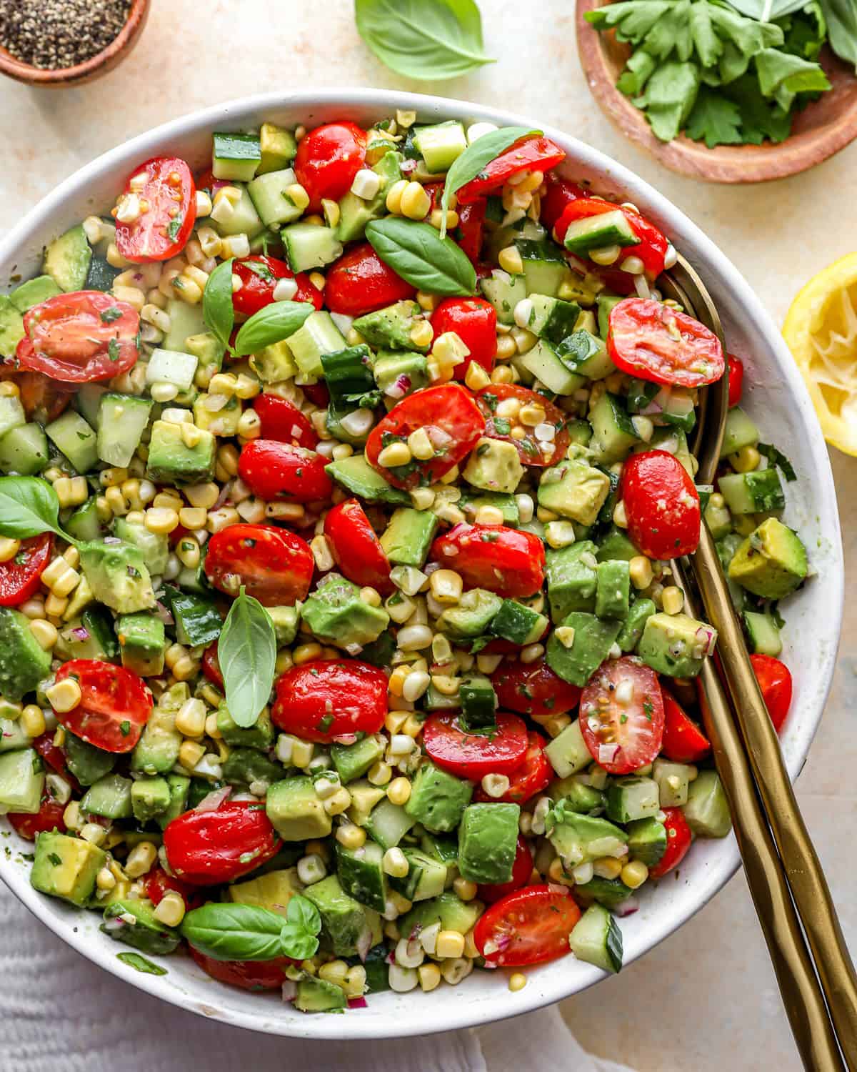 close up overhead view of avocado salad in a white bowl with a serving spoon.