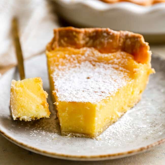 a forkful of chess pie next to a slice on a speckled plate.