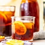 homemade sweat tea in a glass in front of a pitcher of sweet tea