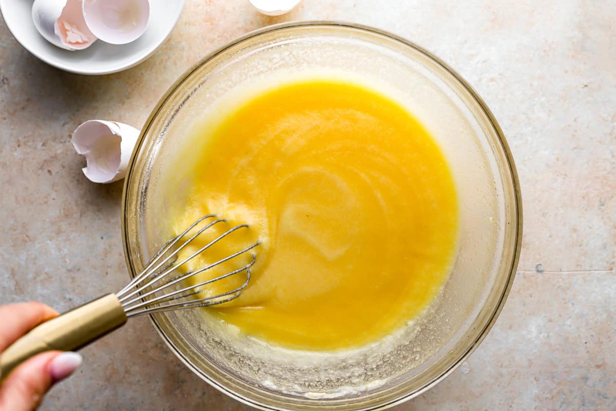 chess pie filling in a glass bowl with a whisk.