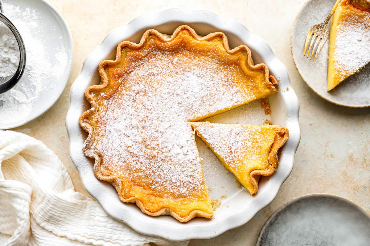 chess pie sprinkled with powdered sugar in a pie pan.