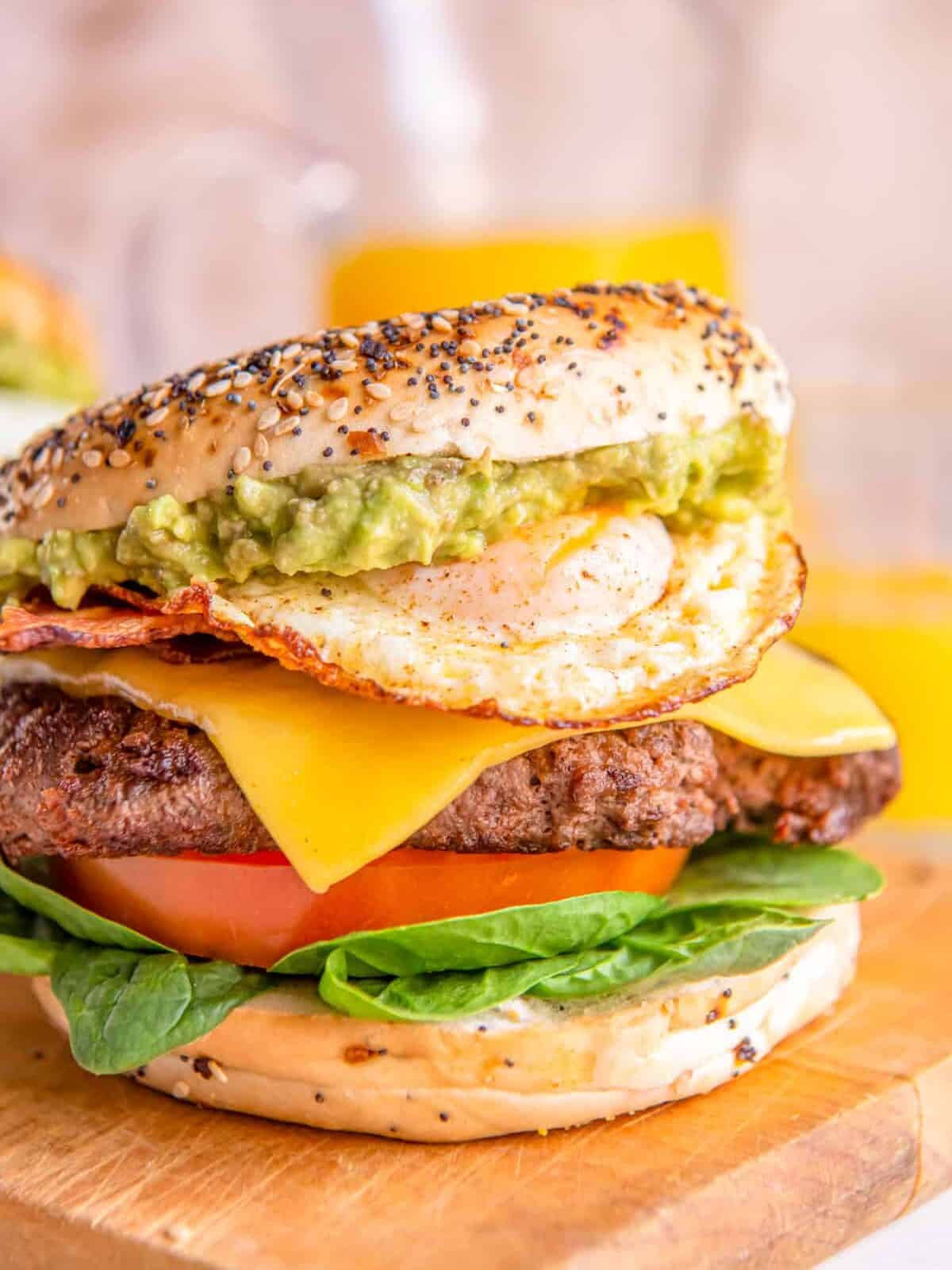 a breakfast burger on a wooden cutting board.