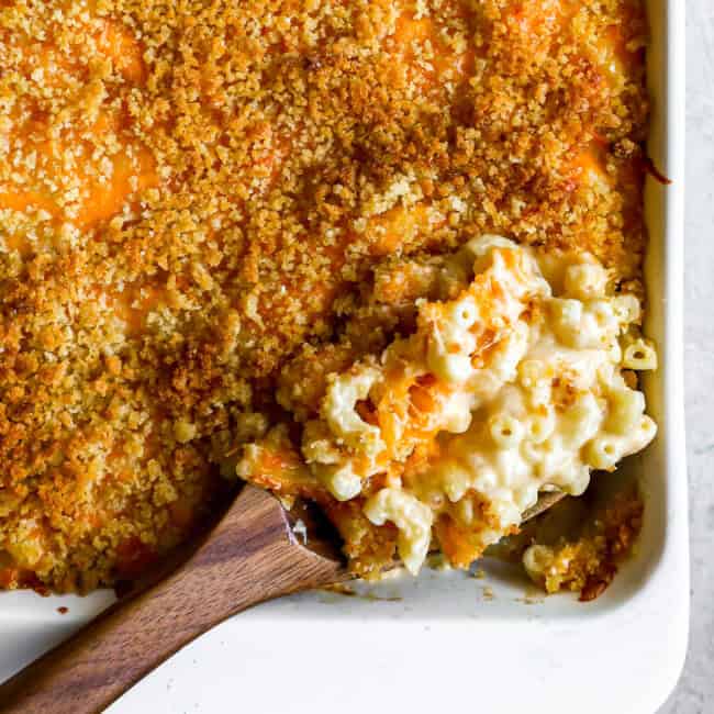 overhead view of a spoonful of baked mac and cheese resting in a casserole dish.