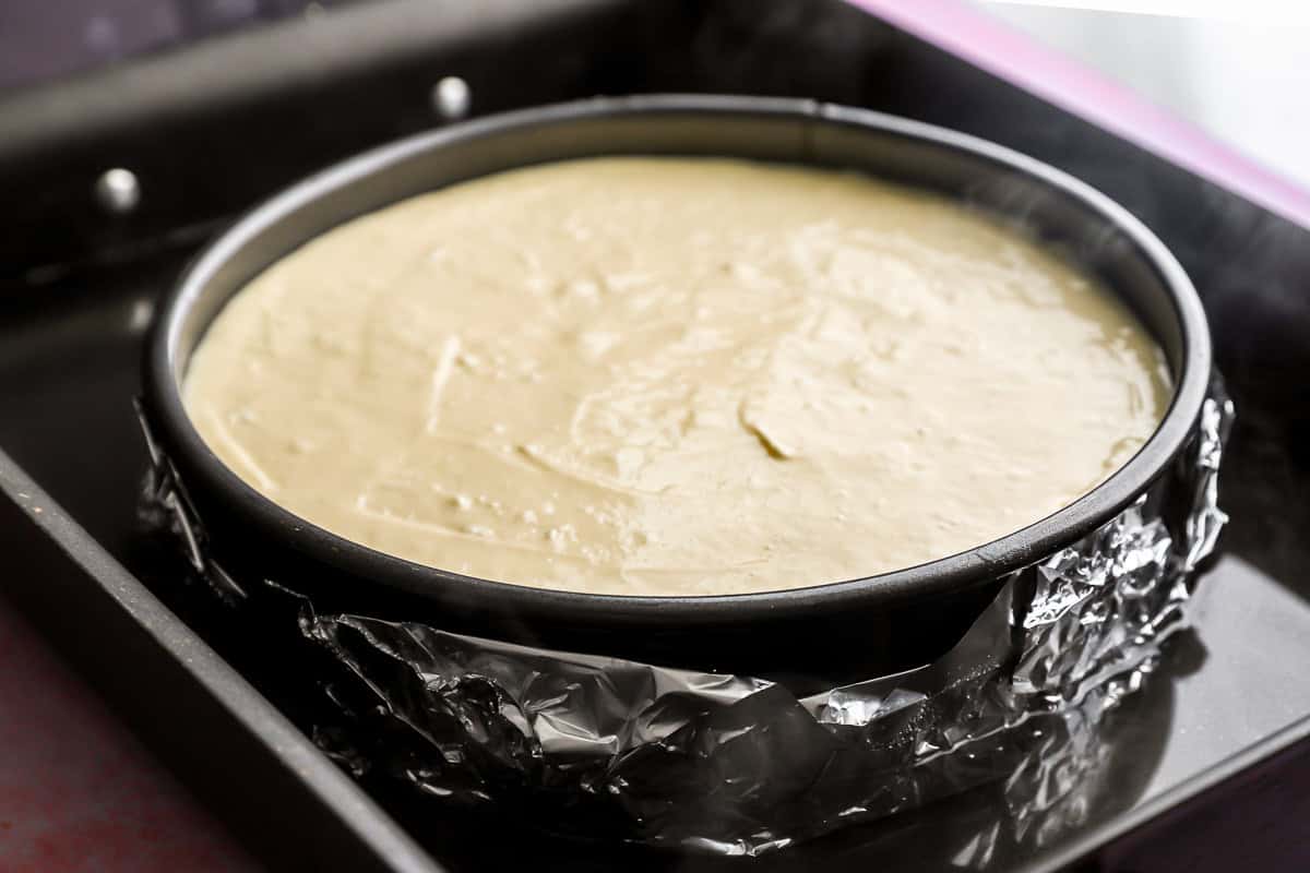 a waterbath setup around cheesecake in a springform pan.