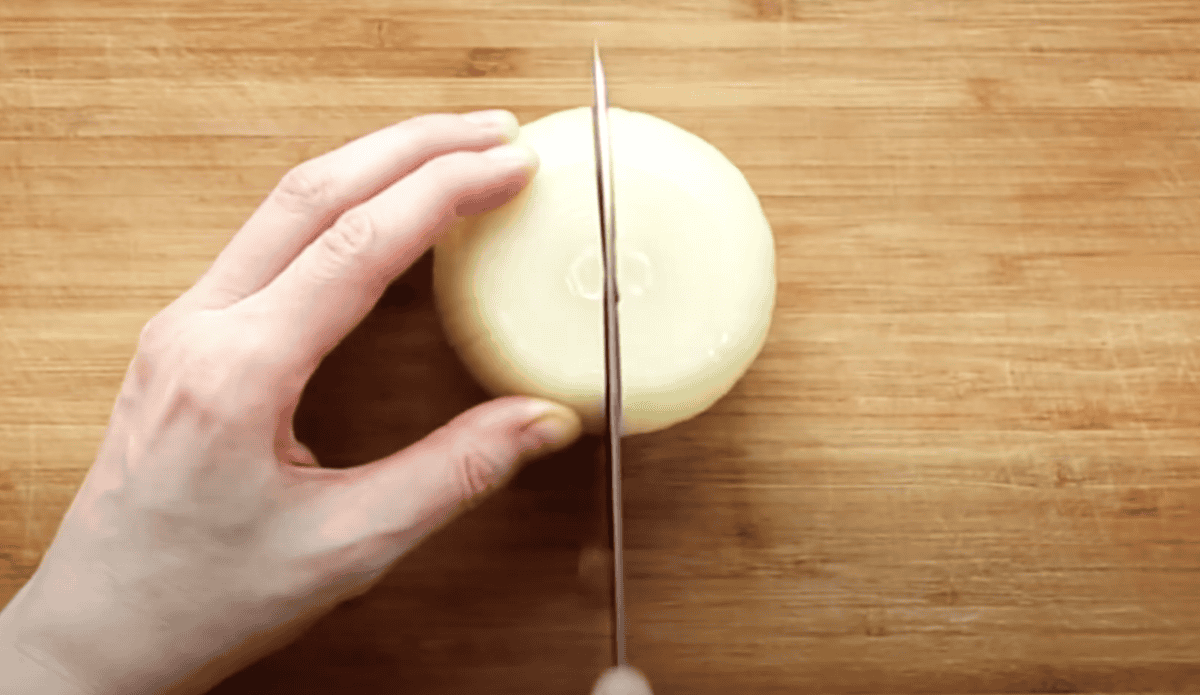 Cutting a peeled onion in half.