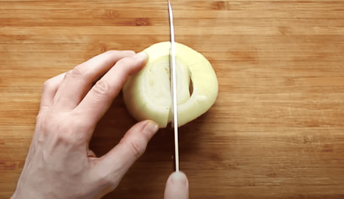 Cutting an onion in half.