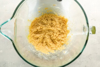 beaten wet ingredients for apple cider cookies in a glass stand mixer bowl.