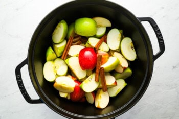 sliced apples topped with cinnamon sticks and cloves.