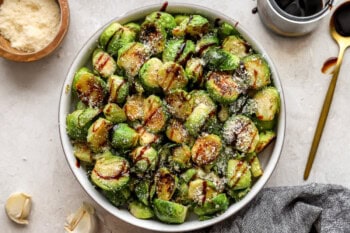 overhead view of garlic parmesan brussels sprouts in a bowl with balsamic drizzle.