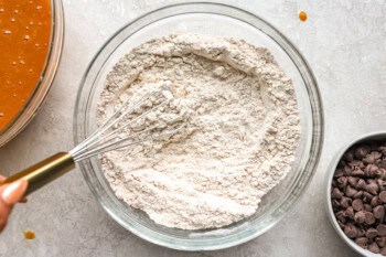 flour in a glass bowl with a whisk.